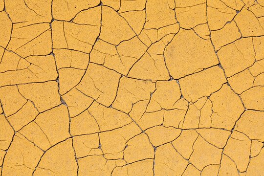 Yellow grungy background. Retro style texture of peeling paint. Weathered cracked paint grunge background surface.