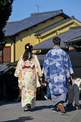 Obraz premium A couple in Japanese national dress walk the streets of Kyoto, Japan