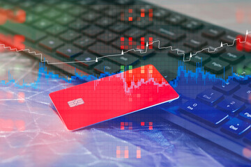 Financial technology with red debit card on a keyboard. Overlay of trading charts, candlestick graphs and colorful data pixels. Digital banking security and cryptocurrency trading.