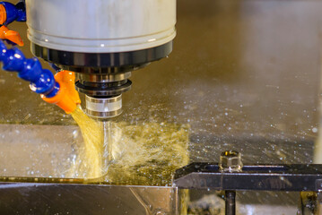 Close up scene the CNC milling machine finishing cut the mold parts with oil coolant method.