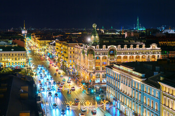 Saint-Petersburg, Russia - Dec 27 2025, panoramic aerial view of Nevsky Prospect with cars driving and illuminated facades of buildings, decorations for holidays, at night, St Petersburg, Russia