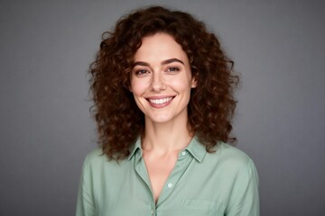 Smiling woman with curly hair in casual green shirt