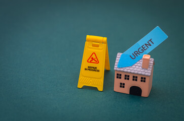Conceptual housing repair urgency illustrated with toy house and repair in progress sign.
