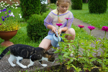 A youthful gardener radiates joy while watering her colorful flower collection with a vintage watering can during a pleasant summer gardening session.