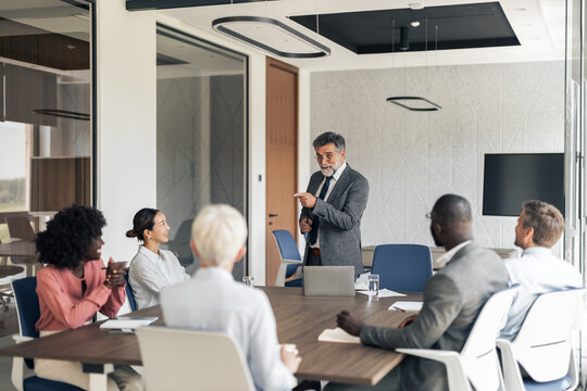 Business leader presenting during office conference meeting with diverse team