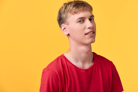 Young man in a red shirt against a bright yellow backdrop, casual vibe, smiling and relaxed, studio lighting, modern fashion mood, upbeat and friendly tone