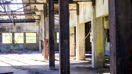 Fototapeta premium Old industrial factory interior with broken windows and steel structure