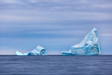 Blue icebergs in the cold, blue waters of the Arctic Ocean at Bontekoe Island, Northeast Greenland National Park.