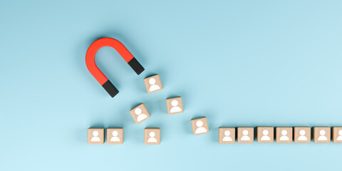Magnet attracting wooden blocks with people icons for customer acquisition concept.