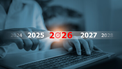 Business goals and 2026 planning concept with businessman touching screen on laptop.