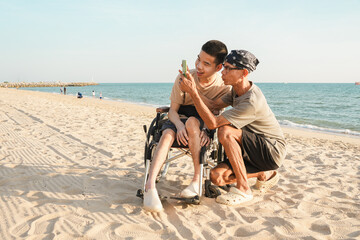 A joyful outdoor lifestyle moment of a wheelchair user and family member taking photos with a smartphone while traveling at the beach, capturing happiness, connection, and inclusive travel.