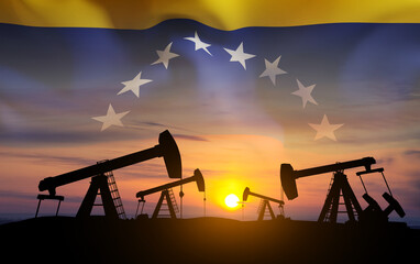 Oil pumpjacks with Venezuela flag against the sunset. Oil industry concept