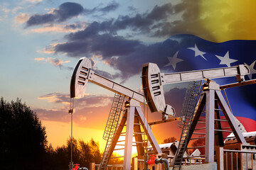 Oil pumpjacks with Venezuela flag against the sunset. Oil industry concept