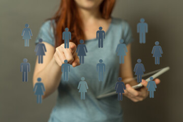 Woman selecting people icons, suggesting networking, connections, and community engagement. Digital concepts.
