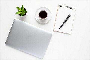 Laptop computer on white desk with coffee cup plant and notebook with pen for business work or study in modern home office