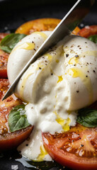 Fresh burrata with tomatoes and basil drizzled with olive oil