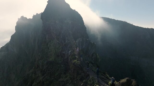 Aerial footage of famous Stairs to Heaven (Escadas do C&eacute;u) on Madeira&rsquo;s PR1 hiking trail. Steep, narrow trail winds between dramatic cliffs, with hikers ascending and descending 