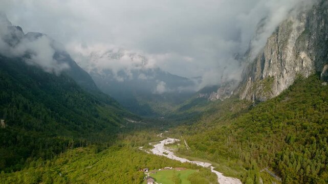 Dramatic alpine valley with deep clouds and mountain peaks, Dolomites, Italy