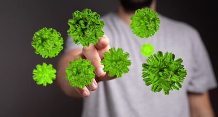 Close-up of a hand reaching for green virus particles, symbolizing the threat of a pandemic or disease. Concep