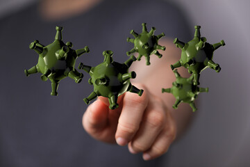 3D render of a hand touching a cluster of stylized coronavirus cells. Representing health, disease, and global