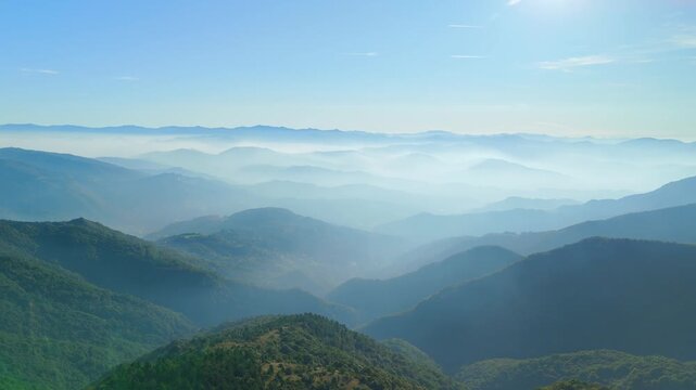 Atmospheric foggy hills under bright sunlight in northern Italy