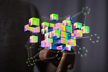 Abstract image showing a hand interacting with a collection of colorful digital cubes and connections. It illus