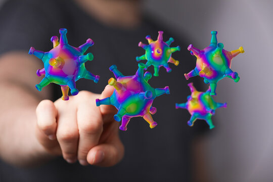 Artistic rendering of a virus model interacting with a hand, symbolizing health, disease, prevention, and tech