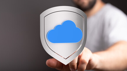 Hand pressing a digital cloud data protection shield. Illustrating cyber security, data privacy, cloud computing, and online safety.