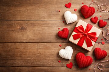 Valentine's Day gift and heart decorations on wooden table