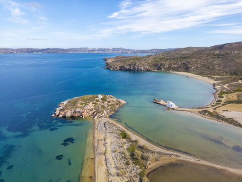 Aerial view of the serene Rivari Lagoon kissed by turquoise waters, where sandy paths meet the island's edge, creating a mesmerizing coastal tapestry, Rivari Lagoon, Milos, Greece.