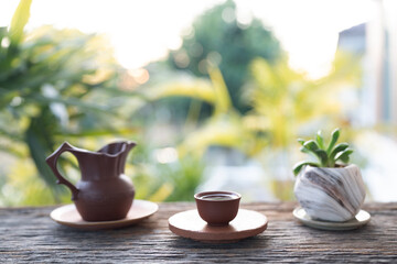 Fototapeta premium Old vintage Earthenware pottery tea set and potted plant arranged on old wooden table