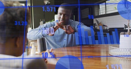 Gesturing man wearing sweater crossing hands at home dining table with child, blue digital overlay