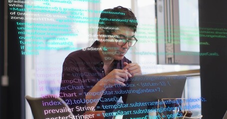 Typing Asian man wearing dark shirt, glasses at modern office with laptop, coffee, reflected code