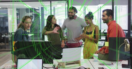Working team gathering around laptop in open office, pointing at green overlay with notebooks © vectorfusionart
