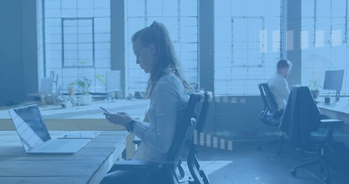 Scrolling woman in long-sleeve shirt checking smartphone at office desk, laptop coat visible - Powered by Adobe