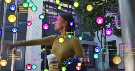 Pointing woman wearing olive top holding takeaway coffee and dark bag on plaza, with chat icons