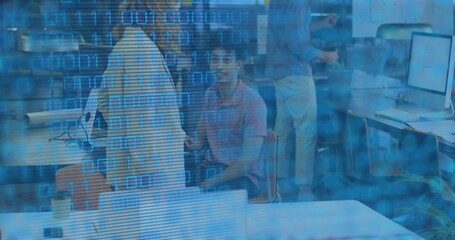 Sitting man in pink polo looking at camera, shared workspace with coffee cup and binary overlay