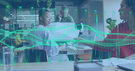 Working four colleagues passing docs in open office, striped blouse and red top, laptop waveform