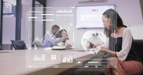Tapping tablet, woman in white blouse presenting data overlay on wall screen at table, copy space