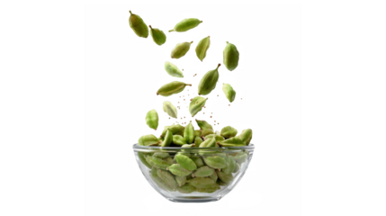 Fresh green cardamom pods descending into a clear glass bowl on a dark background