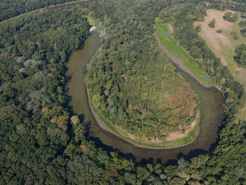 Aerial view of the Oxbow lake of the Morava River embraced by a dense forest, its tranquil waters reflecting the sky, Vysoka pri Morave, Bratislava Region, Slovakia.