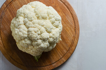Head of fresh cauliflower on wooden board