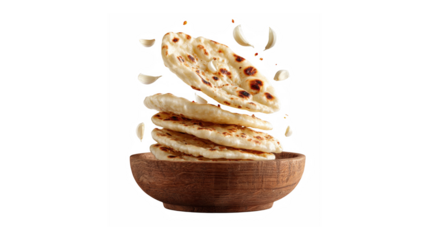 A dynamic stack of freshly prepared garlic naan bread in a rustic wooden bowl with flying ingredients
