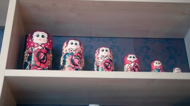 In many Soviet apartments there was traditionally usually a row of matryoshka dolls on a shelf. Closeup. Shot in motion
