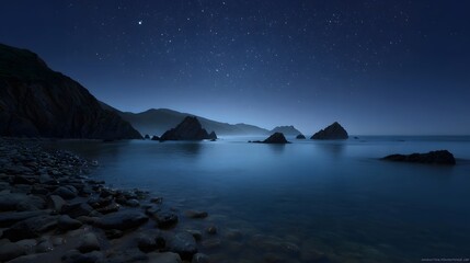 Starry night over a serene rocky coastline with calm ocean and distant mountains