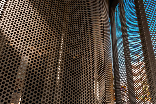 Modern perforated metal bus stop architecture at Gniezno MPK public transport shelter, hub on Łubieńskiego Street square in Poland