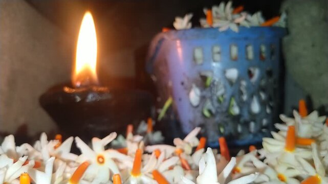 Traditional Oil Lamp with Night Jasmine Flowers Burning in Dark Spiritual Background