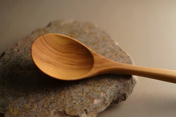 Handcrafted wooden spoon resting on a stone