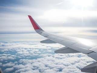 Fototapeta premium Wing soars above fluffy clouds, natural sunlight paints airy scenery. View from cabin captures the joy of travel in serene daytime