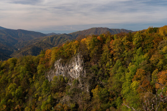 Aerial view of a dramatic cliff face amidst a tapestry of autumn colors, where vibrant foliage meets rugged stone, Baranovo, Banska Bystrica, Slovakia.
